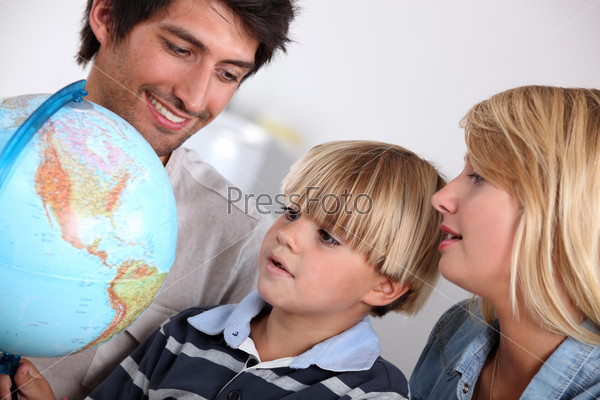 Parents and son looking at a globe
