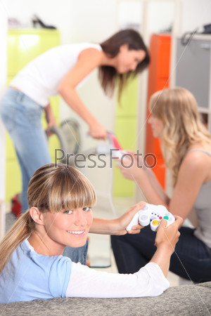 Three female roommates playing video game.