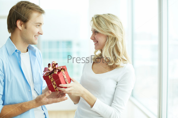 Image of young guy giving present to his girlfriend on her birthday