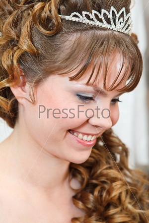 Beauty young Caucasian woman with curly hair and crown on head