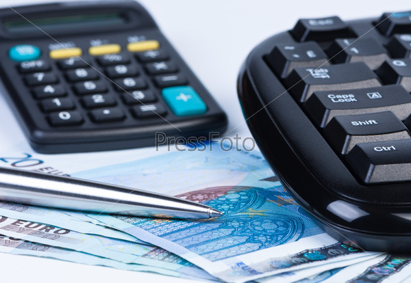 Euro money calculator, keyboard and ball pen close up