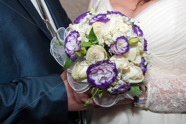 blue and white wedding bouquet in the hands of the bride and groom
