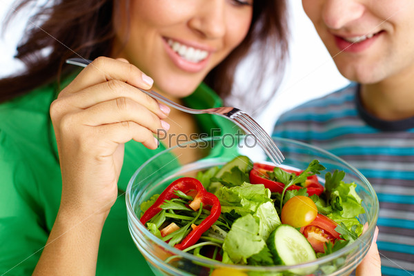 Close-Up Of Young Couple Eating Vegetable Salad From Glass Bowl