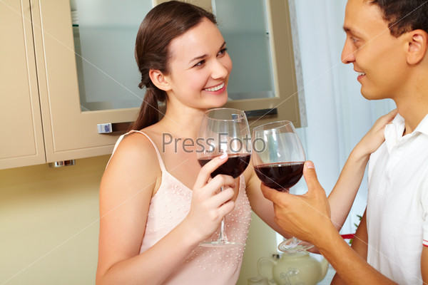 Portrait of amorous couple with wine toasting in the kitchen