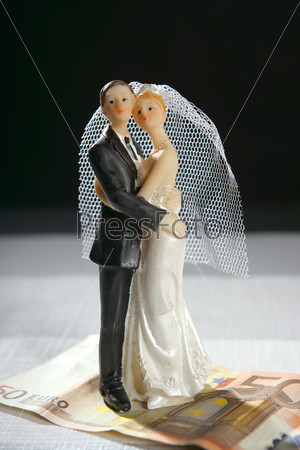 Love over money metaphor, wedding figurine and euro note