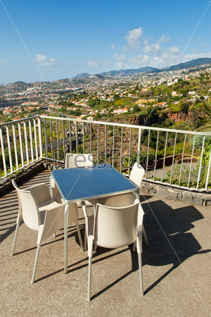 Wide angle shot of empty cafe tables high over Funchal city, Madeira, Portugal