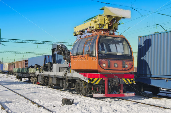 Train crane carriage. Hydraulic crane mounted on a railroad car (freight train) for lifting the timber.  Special railway wagon.