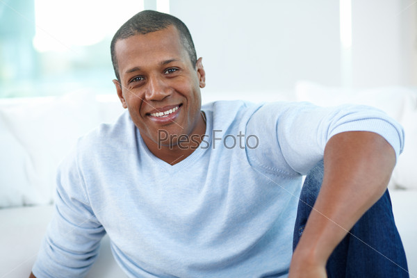 Image of young African man looking at camera with smile, stock photo