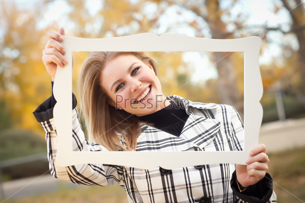 Pretty Young Woman Smiling in the Park on a Fall Day with Picture Frame.