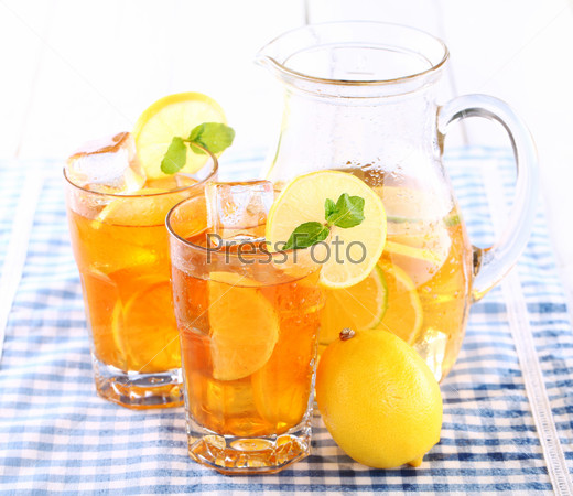 Close up of fresh and cold ice tea with sliced lemon and mint