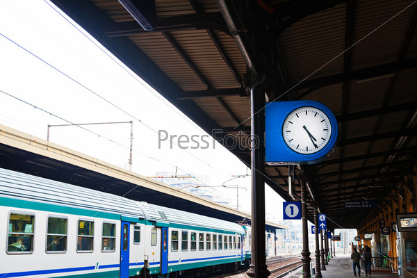 Часы и поезд на железнодорожной платформе
