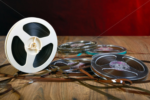 Reels of magnetic tape on a wooden table, stock photo