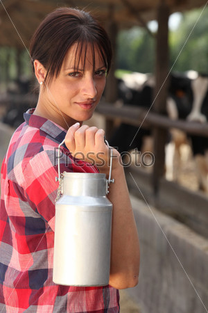 Farm worker holding milk container