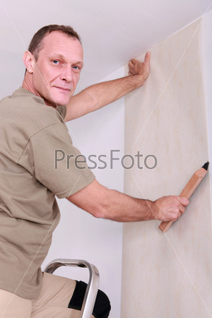 Man hanging wallpaper