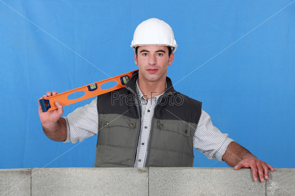 Man stood by wall with spirit-level