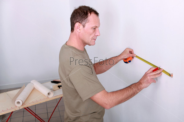 Man measuring wall