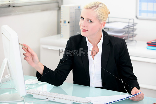 Blonde woman working at a clean modern desk