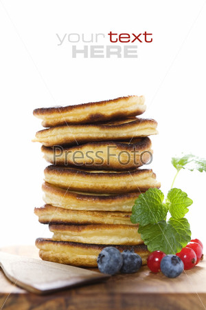 Stack of freshly prepared pancakes with berries on white background (with sample text)