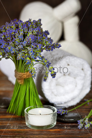Fresh  lavender flowers, zen stones,Herbal massage balls , candle and towel over wooden surface