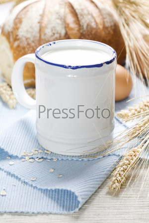 wheat, bread, milk and eggs on a blue napkin