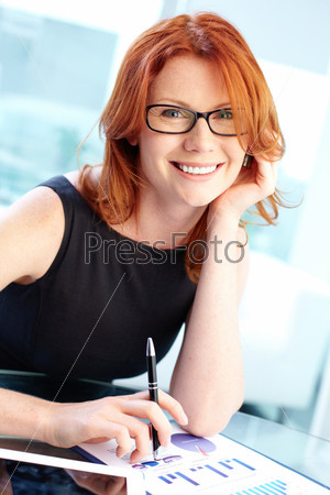 Successful business lady smiling at the camera while working in office
