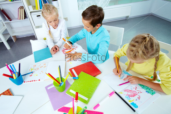 Trio of friends enjoying drawing in an after-school club