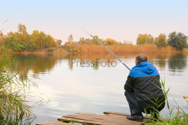 Мужчина рыбачит на озере