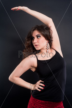 Young brunette lady in black top posing on black background