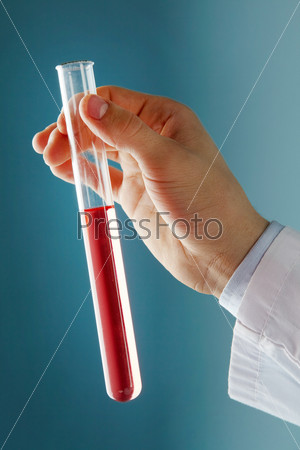 Close-up of glass tube with red fluid in scientist hand during medical test