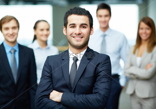 Group of friendly businesspeople with male leader in front