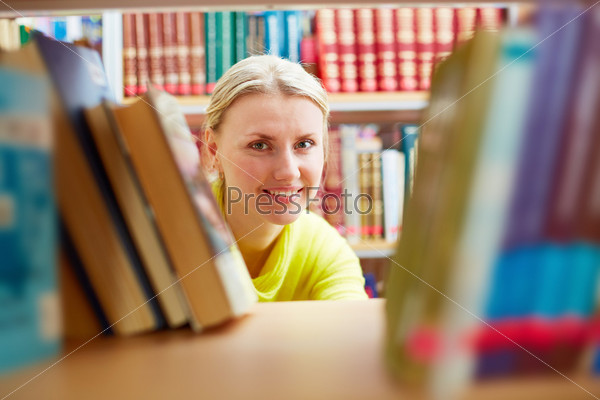 Portrait of pretty girl looking at camera with smile in college library