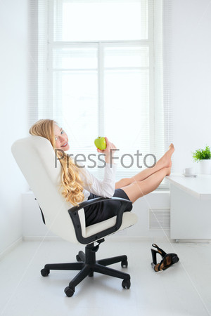 happy office girl eating apple at break