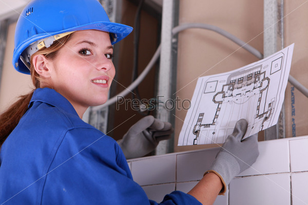 Brunette electrician holding diagram