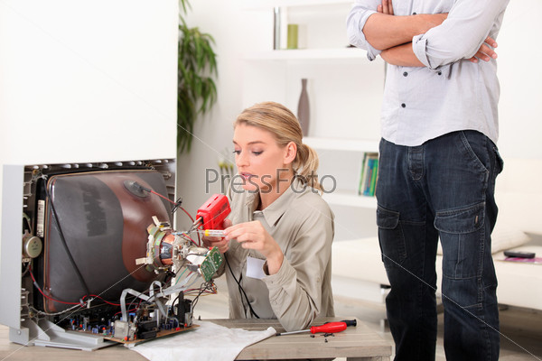 A female technician repairing a television