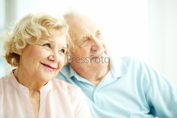 Close-up portrait of a charming elderly woman with her husband on background, stock photo