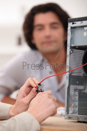 close-up of hands fixing computer