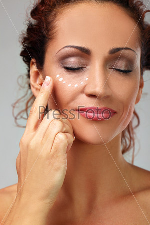 Natural middle aged woman with cream, stock photo