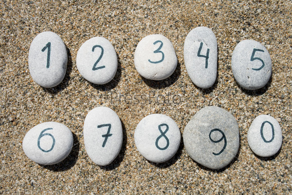 0 to 9 digits on group of stones with sand background