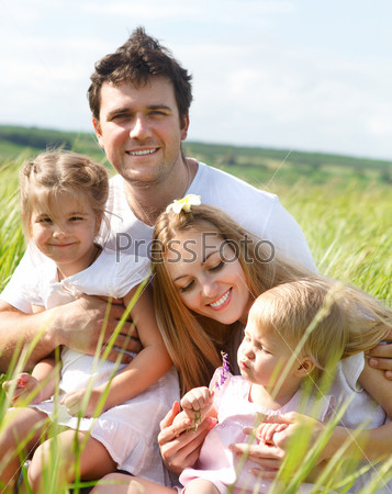 Happy young family with two children outdoors in summer day