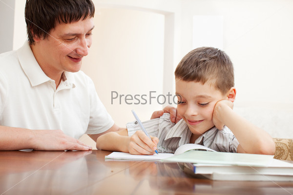 Father helping son do homework. Parent helps his child