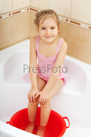 Child holding his feet in cold water. Harden. Tempered.