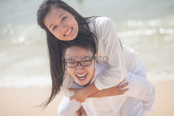 Happy young girl enjoying piggyback ride on her boyfriend
