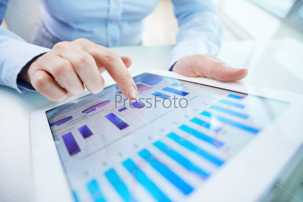 Image of human hand pointing at touchscreen with business document