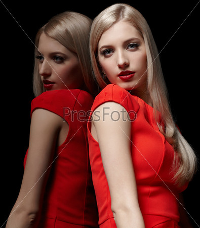 portrait of young beautiful long-haired blonde woman in red dress at mirror