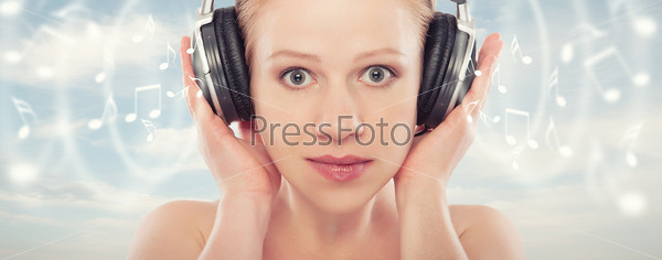 musical concept. woman with headphones relax, enjoy the music on the sky background with notes