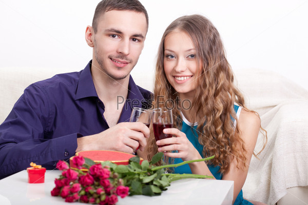 young happy  couple  drinking red wine at home interior, they looking at camera