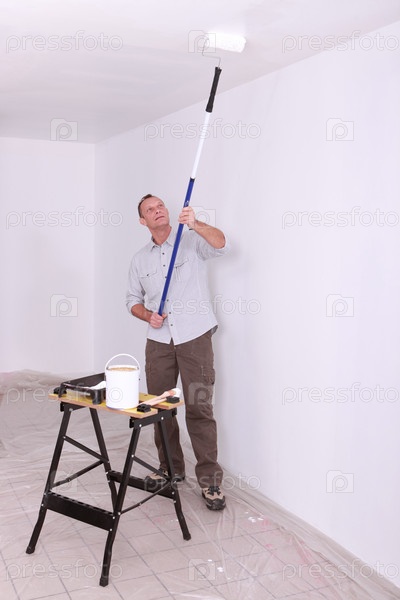 Laborer painting ceiling