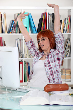 Girl doing homework stretching at her desk