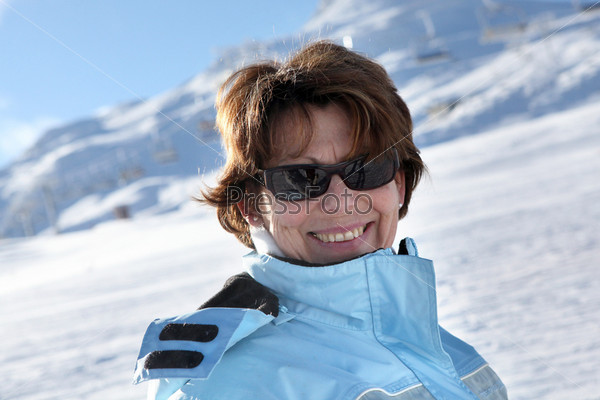 Middle-aged woman stood on snowy mountain