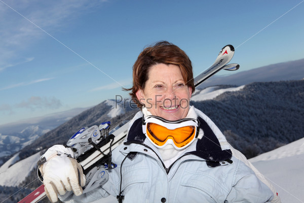 Portrait of a senior woman with skis in snow